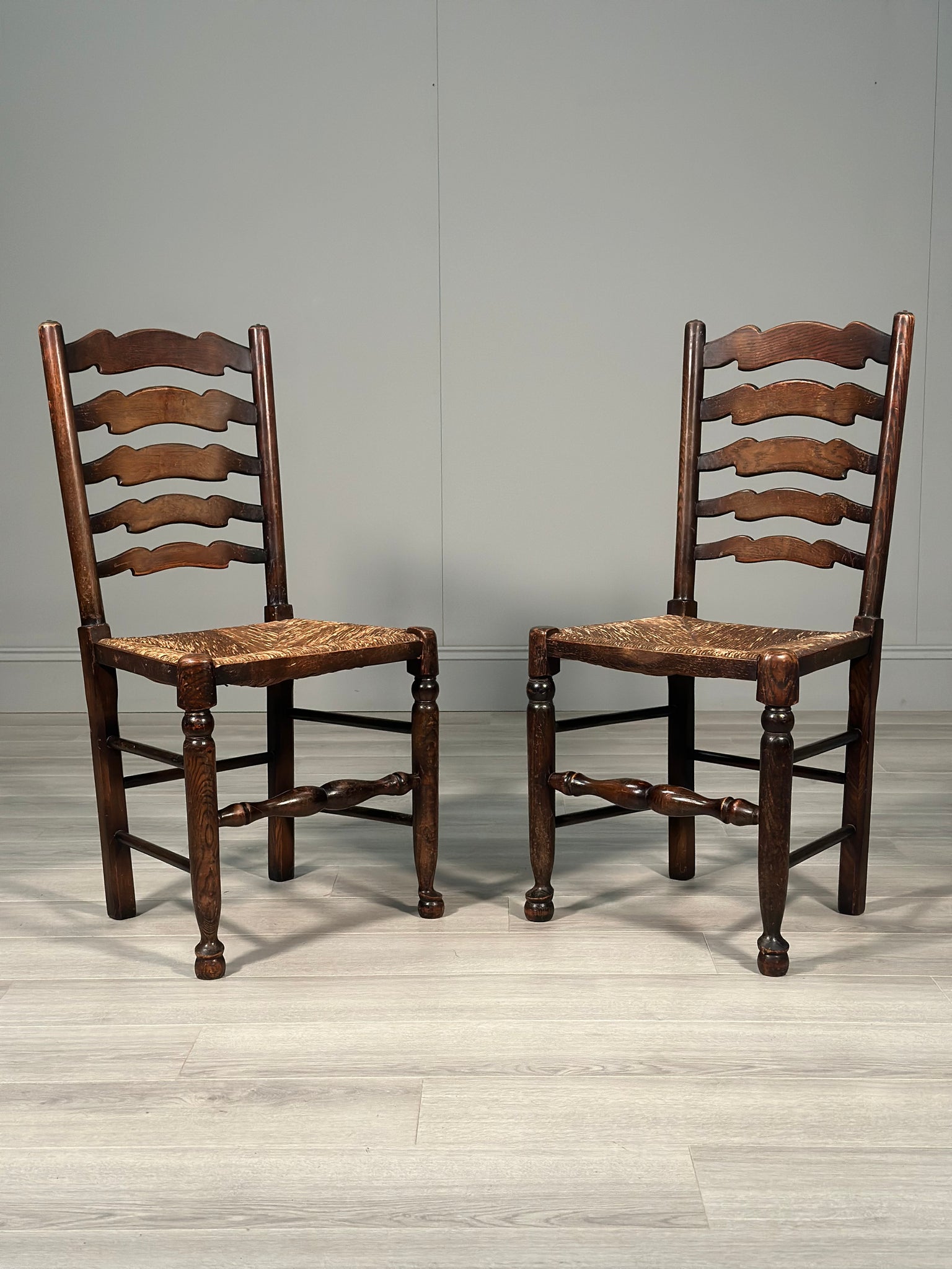 A Pair Of Antique Elm Rush Ladderback Chairs